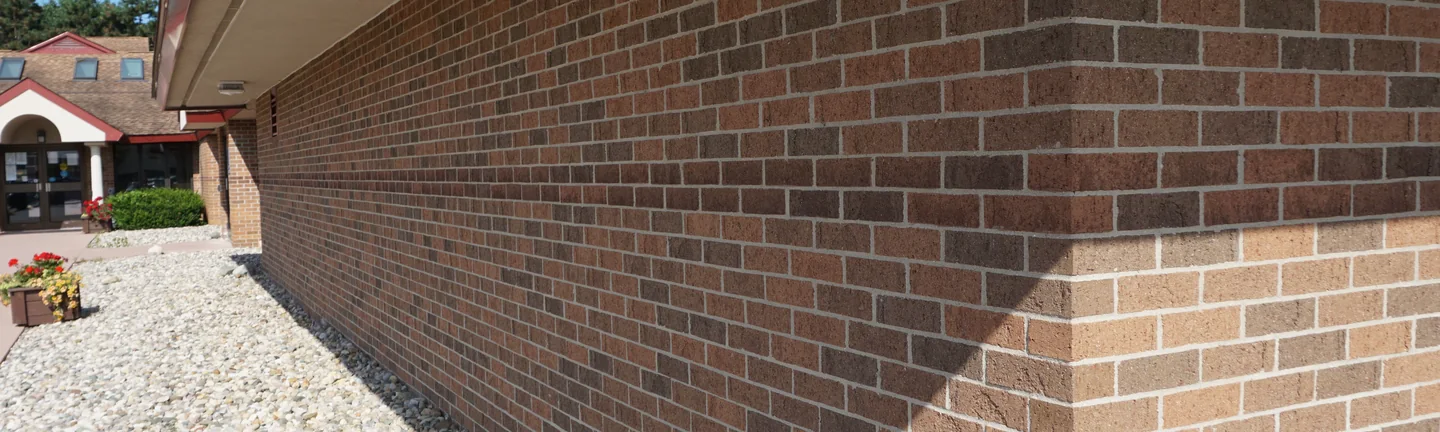 The wall of the Michigan office in 2019, a band of darker brick running the length of it toward an outside corner