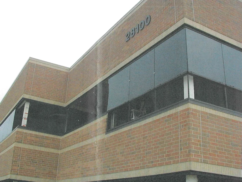 The outside corner of the same office in 2003 seen from below, the brick uneven in color between the upper and lower bands
