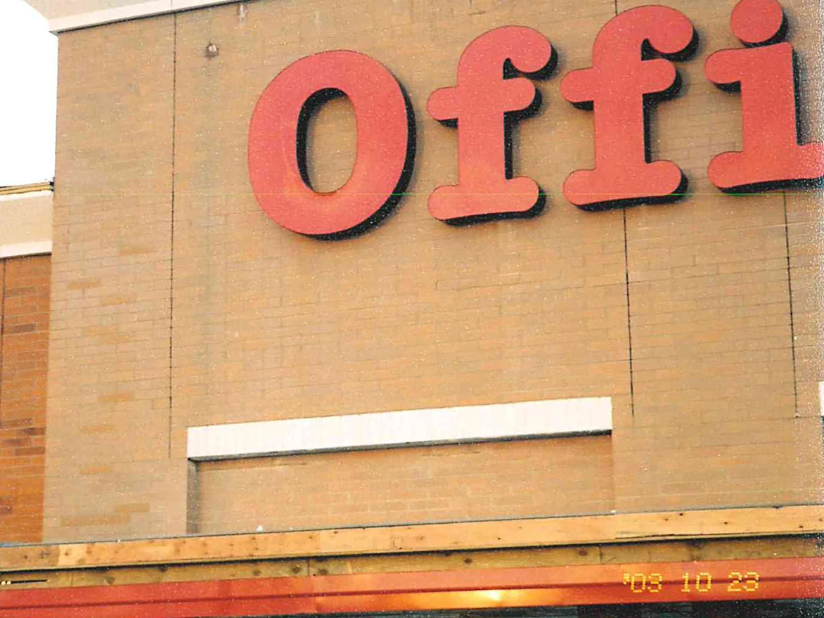 The corner where the block pilaster carrying the store sign meets the brick return in 2003, the block an uneven buff