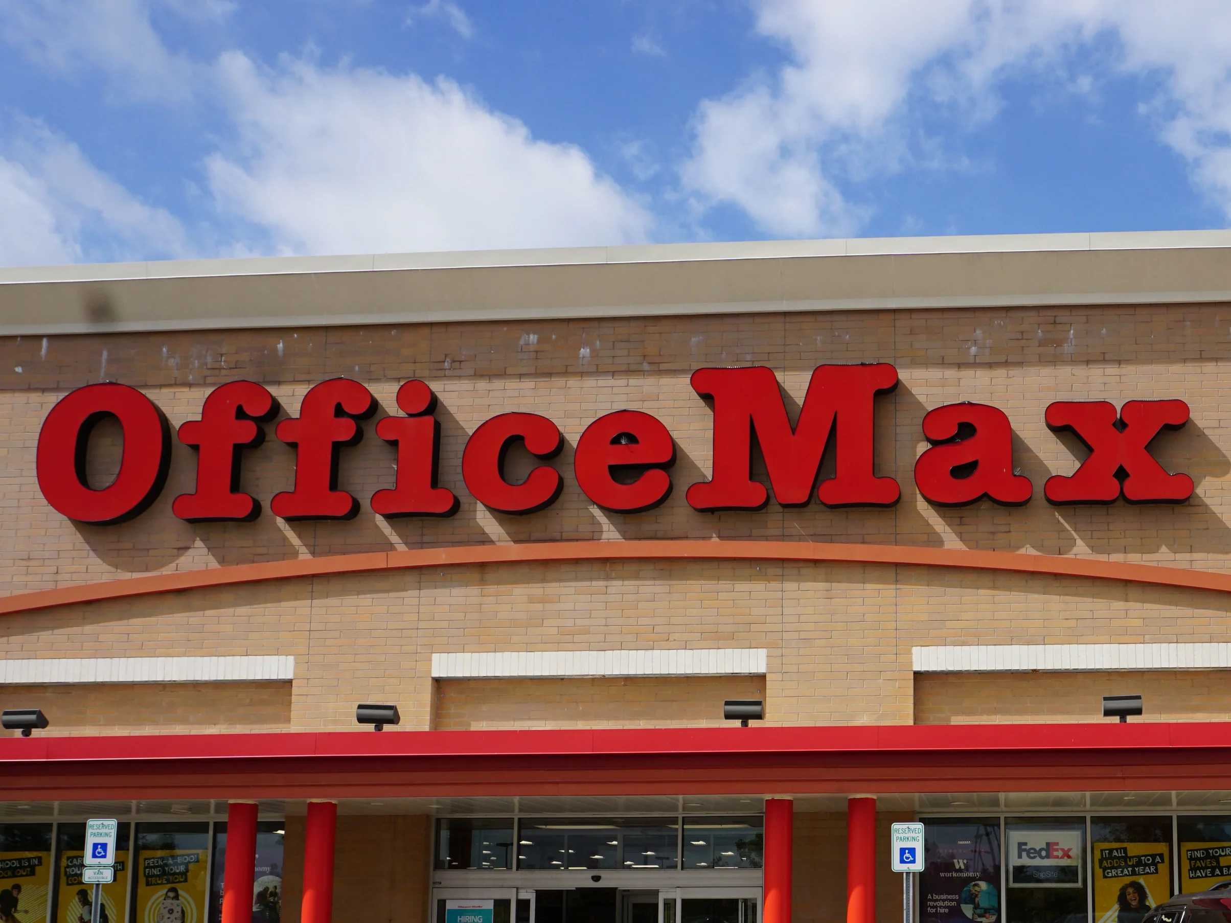 The storefront in 2019, the concrete block under the sign reading as one even buff and tan range across the elevation