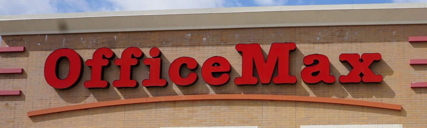 The store sign standing on a concrete block wall that reads as one even buff and tan range in 2019