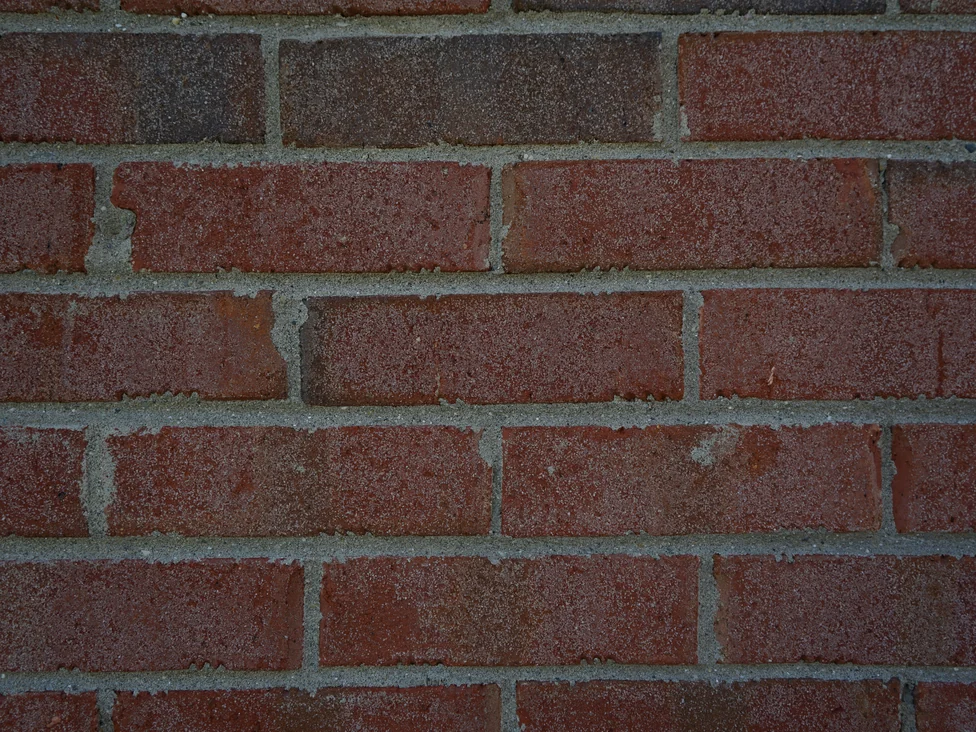Close view of the brick in 2019, individual units in mixed reds and browns with pale mortar joints, even in color across the face