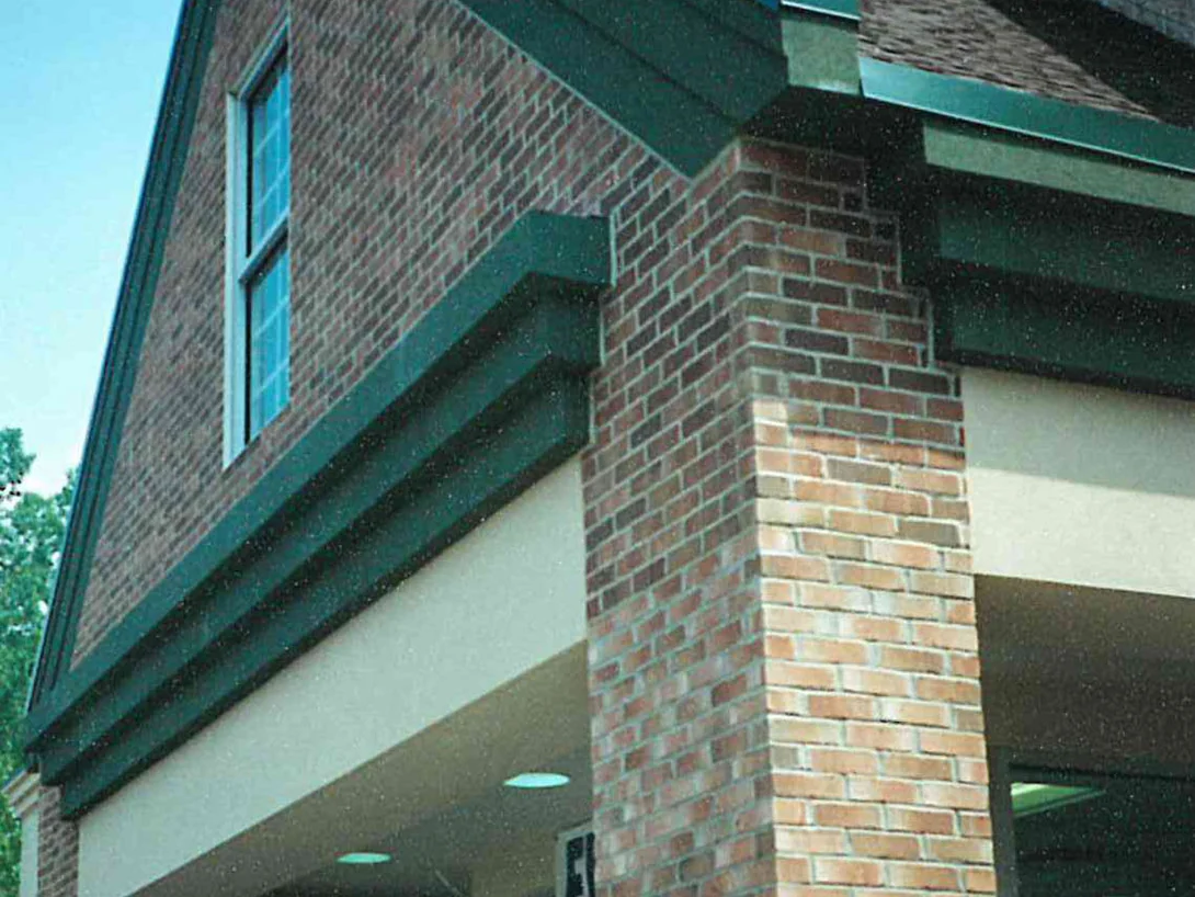 A brick column at the store entrance in 1997, its units a pale salmon and cream against the darker red brown brick of the gable behind it