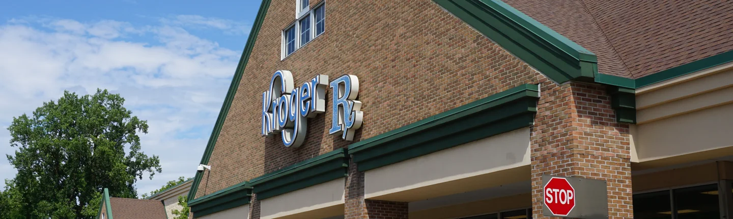 The gabled brick entrance of the Kroger in 2019, its columns and wall reading as one red and brown range