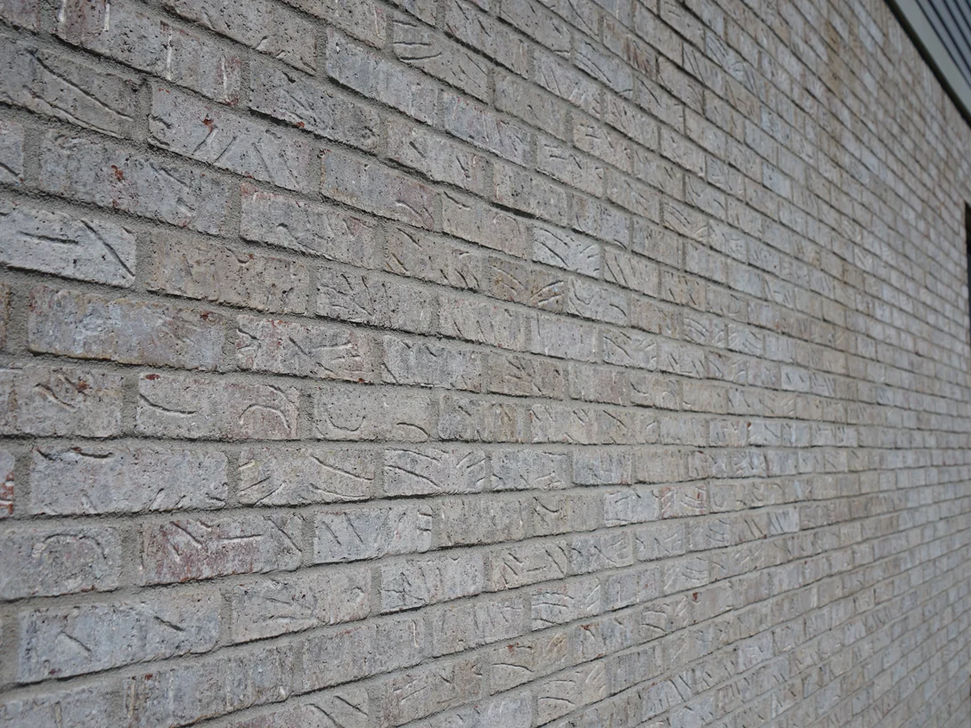 Close raking view along the brick coursing in 2019, each unit a slightly different tone inside one range