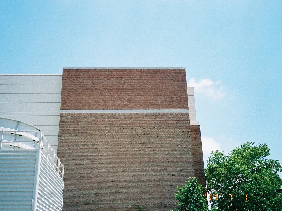 The top of a brick end wall in 2004, the band above the limestone course reading distinctly redder and darker than the brick below it