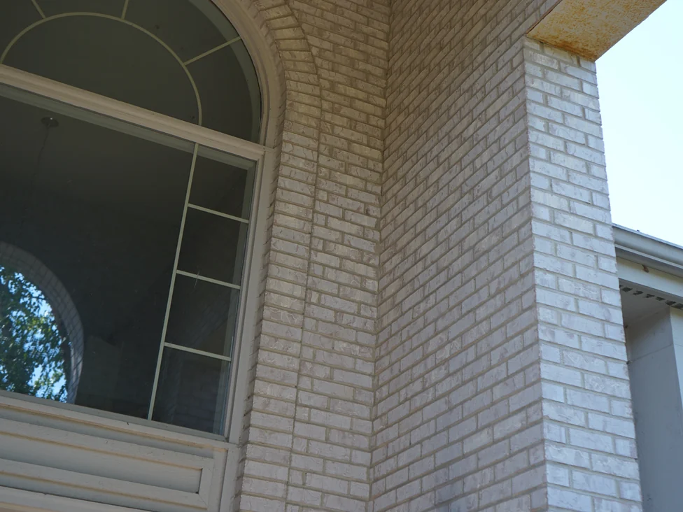 The same outside corner of the entry porch in 2019, the white brick courses turning the corner beside the arched window