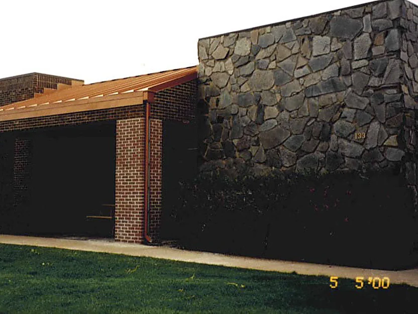 The entrance in 2000, the newly added brick column pale against the dark brown wall on either side of it