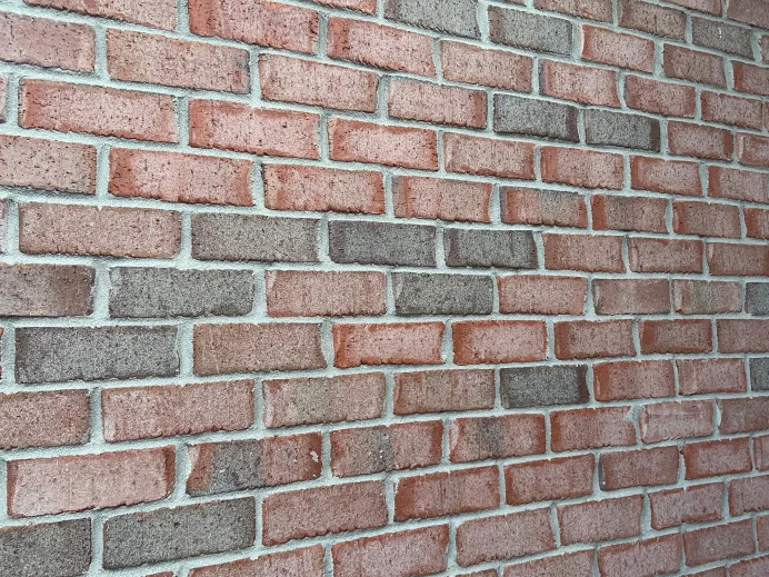 A close view of the wall in 2019, salmon and grey units set course by course so no single brick stands out of the range