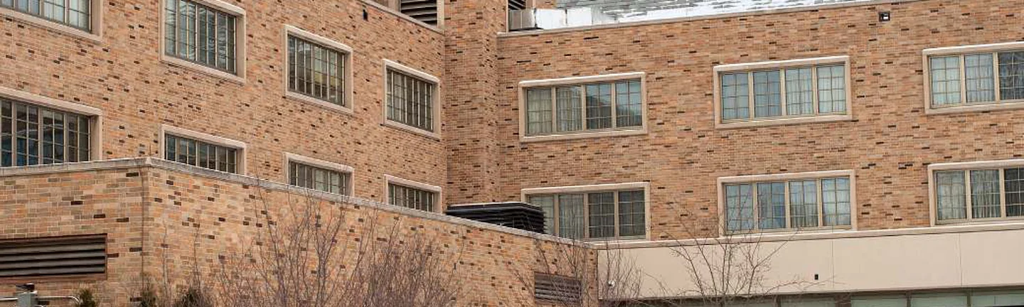 The older wing of the campus inn in 2019, brick reading as one tan and brown range across three storeys