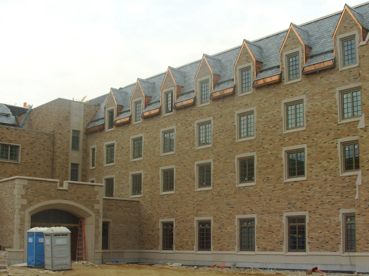 The four-story wing still under construction in 2010, its brick a pale buff with only a thin scatter of darker units under the row of dormers