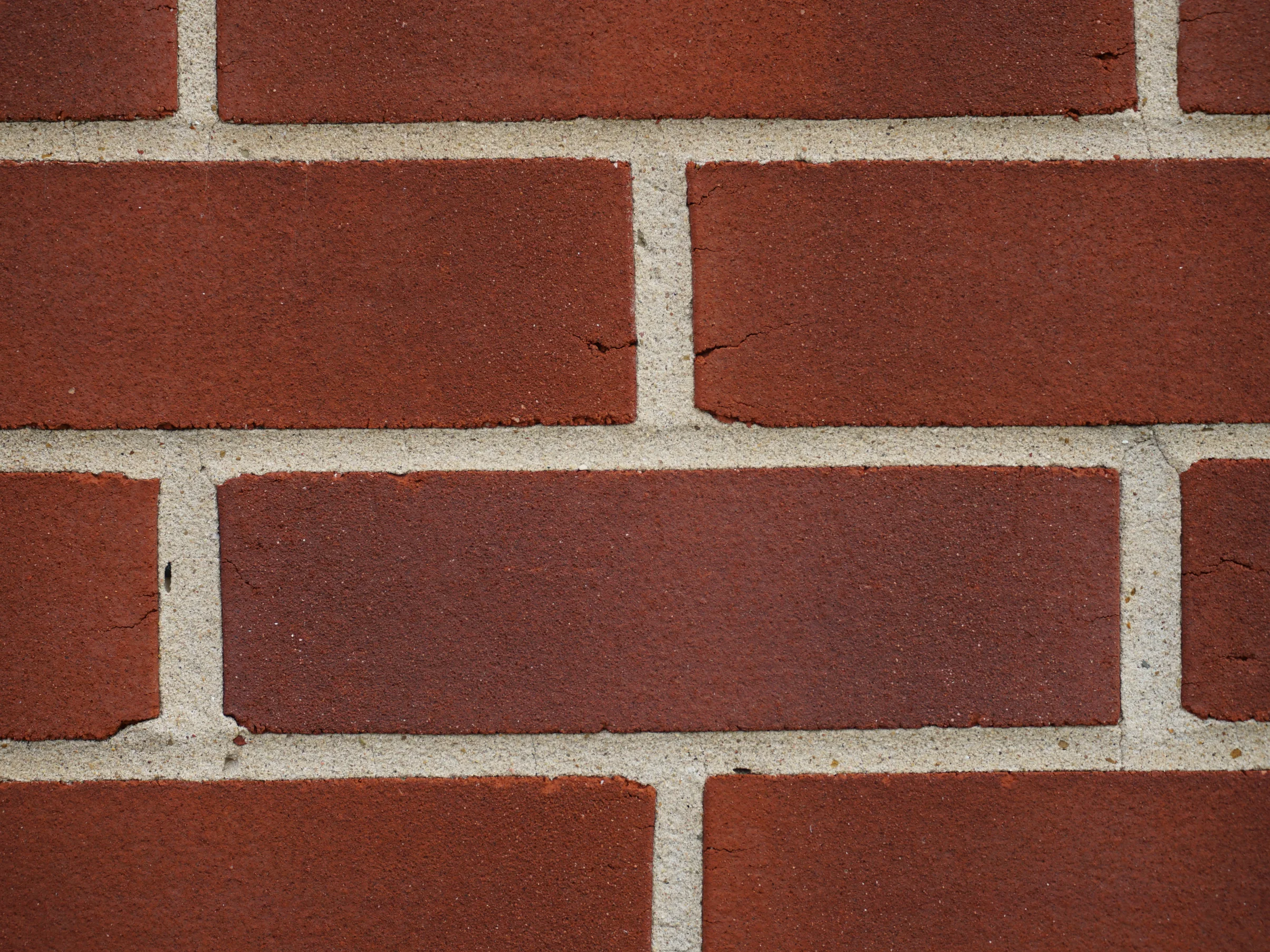 Close view of the hospital brick in 2019, red and darker red units sitting side by side in pale mortar joints