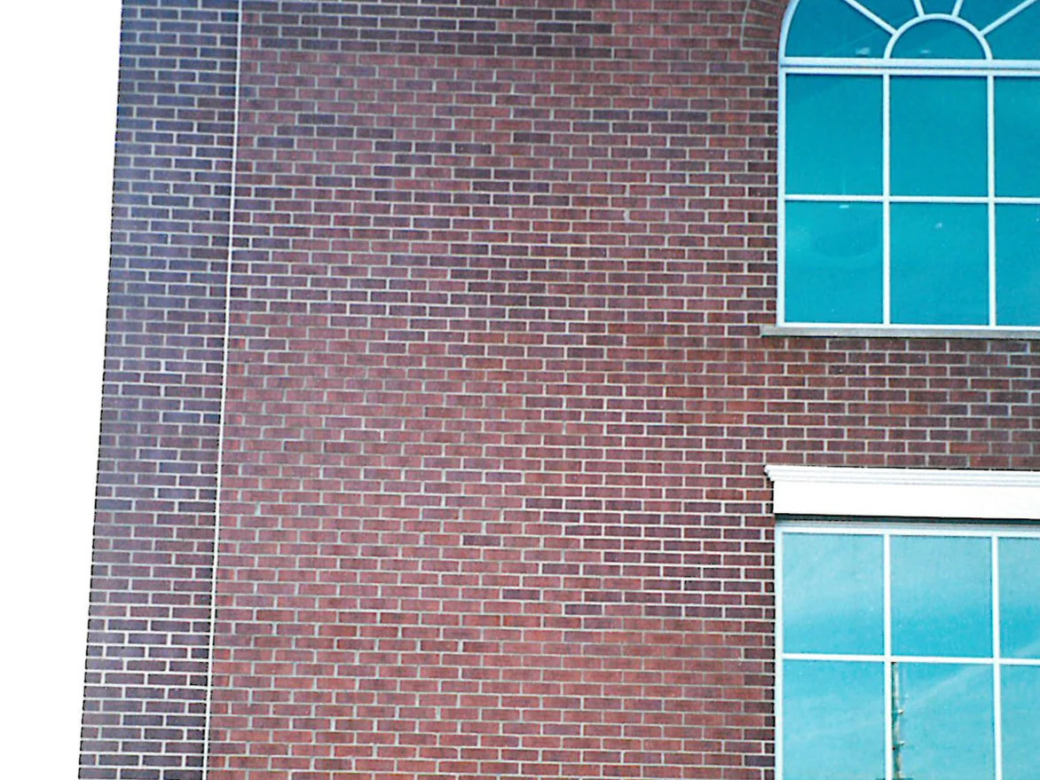 A two-storey brick wall on the hospital in 1998, a broad field of it reading duller and browner than the courses running round the corner beside it