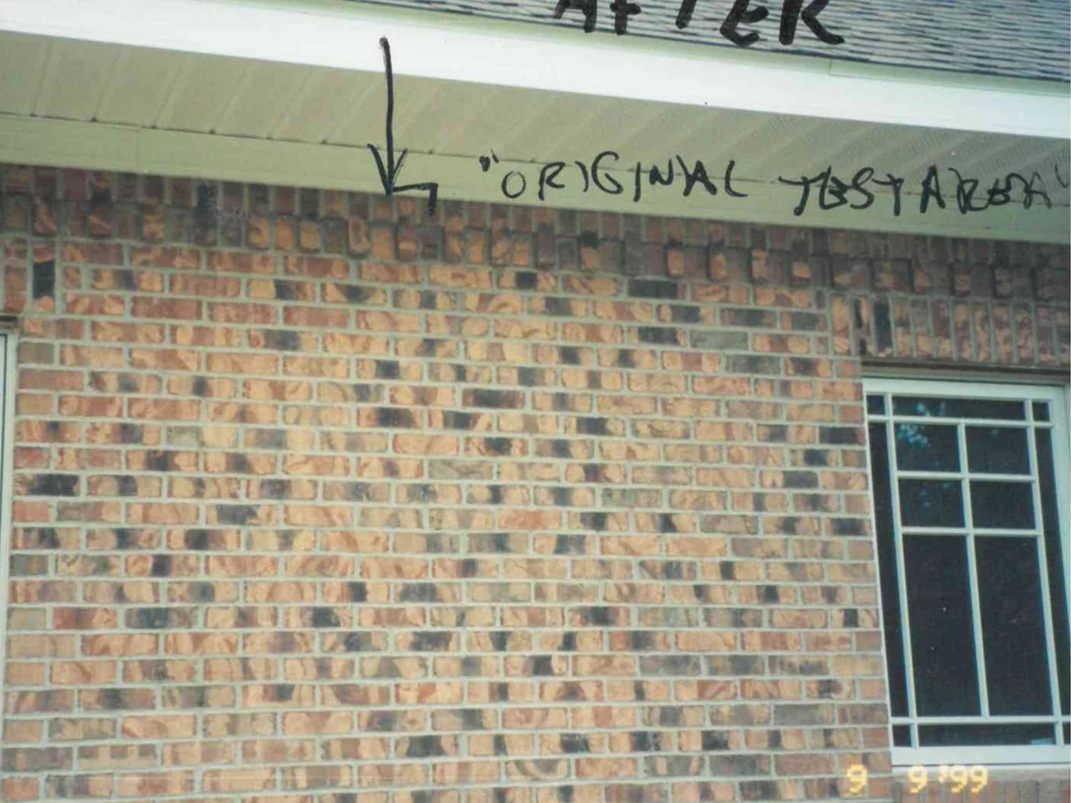 The same wall on September 9, 1999, the whole elevation reading as one blend of tan and dark brick, with the original test area marked in pen under the soffit