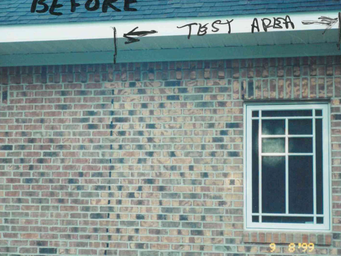 The side wall of the Nashville, Michigan home on September 8, 1999, two runs of brick reading as different colors, with a test area marked in pen to the right of a drawn line