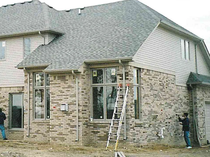 The side wing on 23 November 2003, a ladder at the bay window and an applicator on a second ladder at the far corner, the brick around him already carried into range