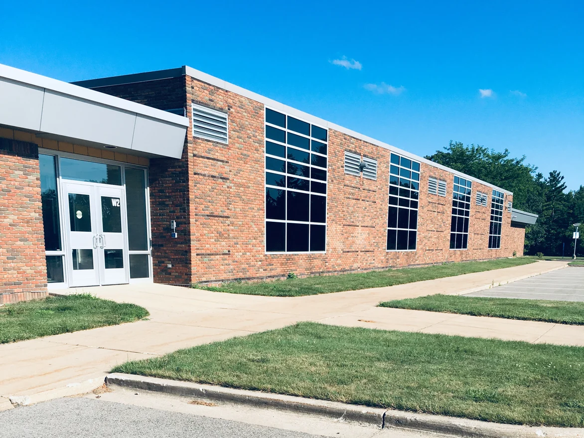 The school in 2019 from its entrance end, a run of tall windows going away down a wall of red and tan brick