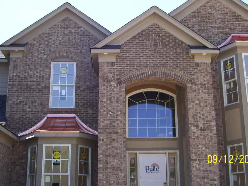 The front of the new house in September 2007 with a builder sign still in a ground floor window, the brick around the two-storey arched entry running from grey brown through pink, and a burned-in camera date of 09/12/2007
