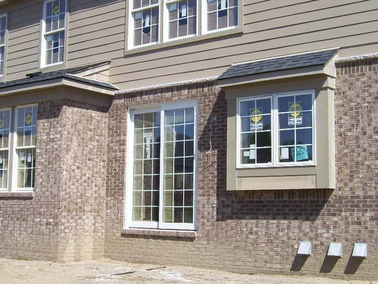 The rear corner in September 2007, a bay window above three dryer vents, the courses below the sills reading noticeably pinker than the brick above them