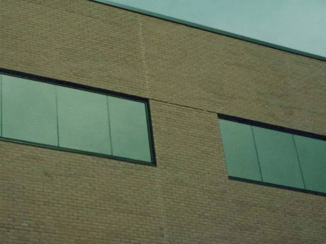 The upper wall in 1999, a vertical expansion joint running down between two ribbon windows with a pale zipper of lighter header brick beside it