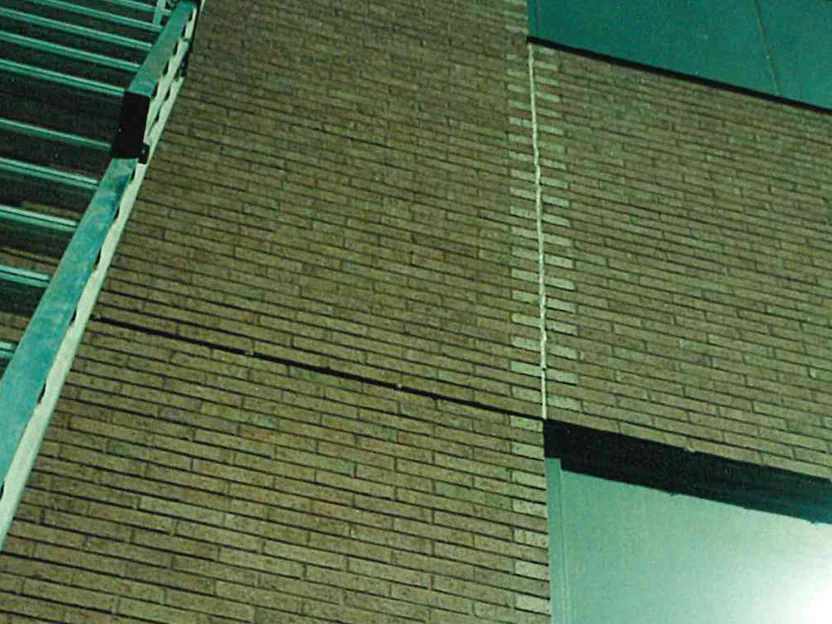 Looking up the wall beside an extension ladder in 1999, a column of lighter header brick running up the expansion joint next to the field brick