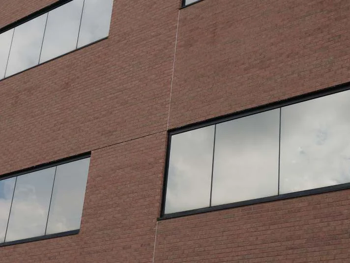 Two rows of ribbon windows in 2019 with the expansion joint running between them, no band of off color brick beside the joint