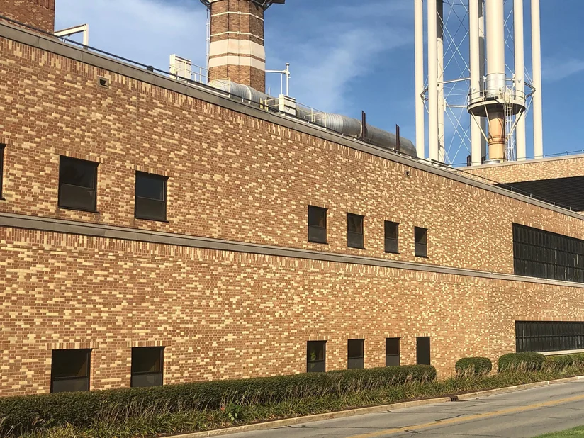 A university power plant in 2019, five runs of brick reading as one wall