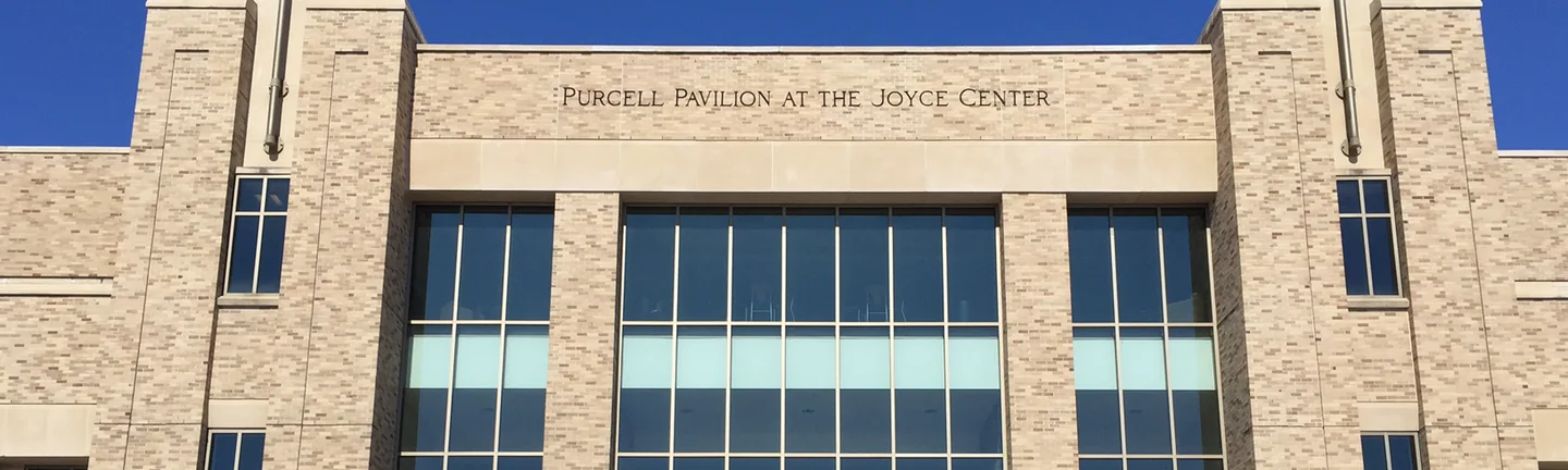 The upper front of Purcell Pavilion at the Joyce Center, its name cut into the stone band above the windows