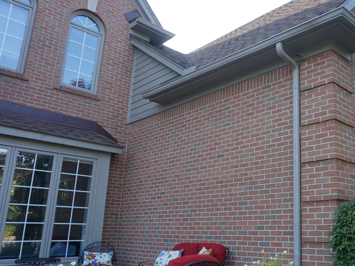 An outside corner of the house in 2019 above the terrace, the brick carrying the same red range across both faces and around the pier