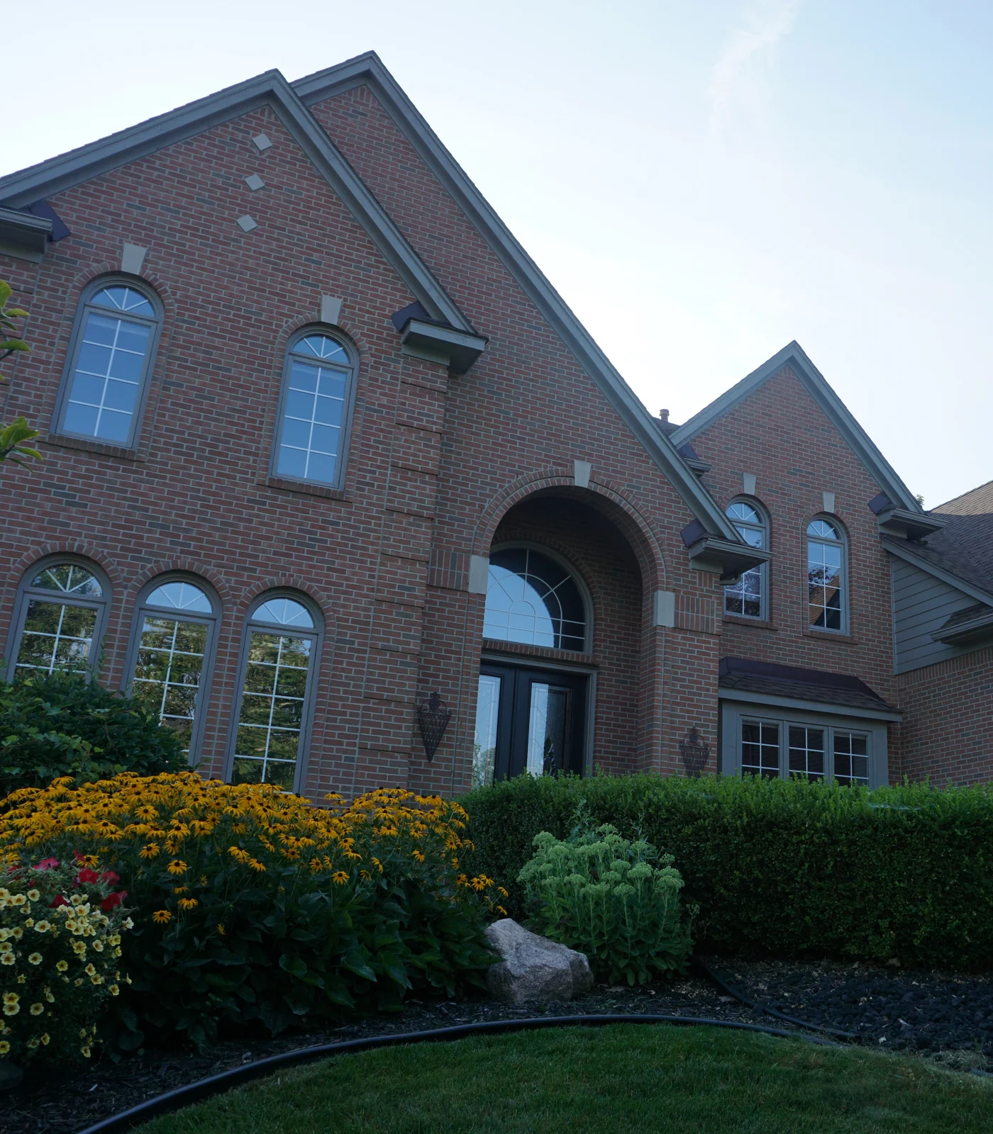 The front of a Novi, Michigan home in 2019, its red brick one even range around the arched windows