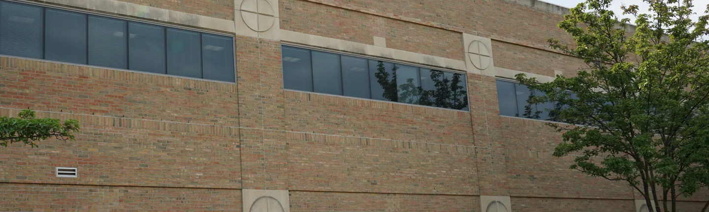 The courtyard wall of the hospital in 2019, its brick holding one tan and red range between cream precast piers