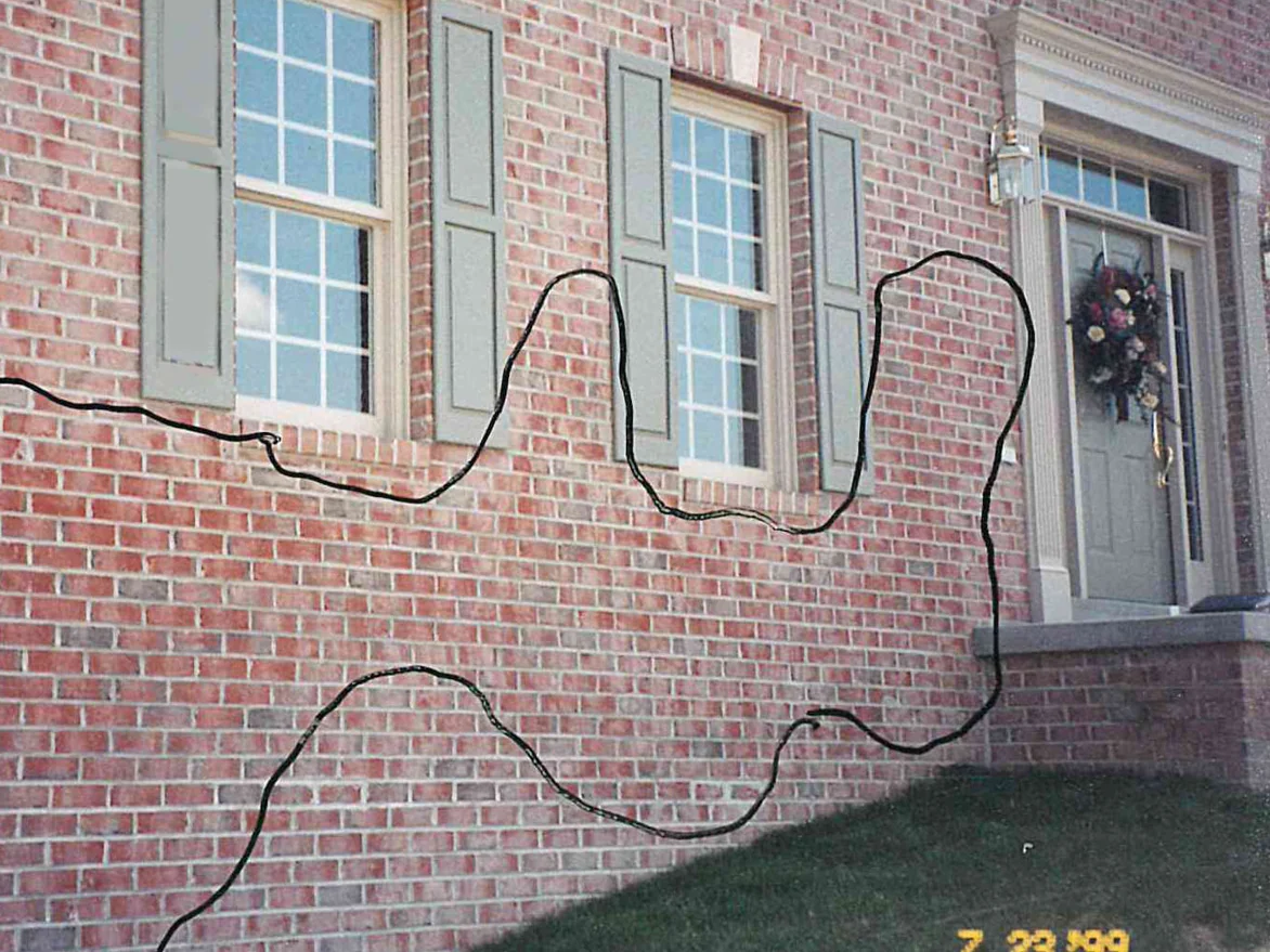 The front of the house in 1999, with a line drawn on the photograph around the run of off color brick to the left of the entry door