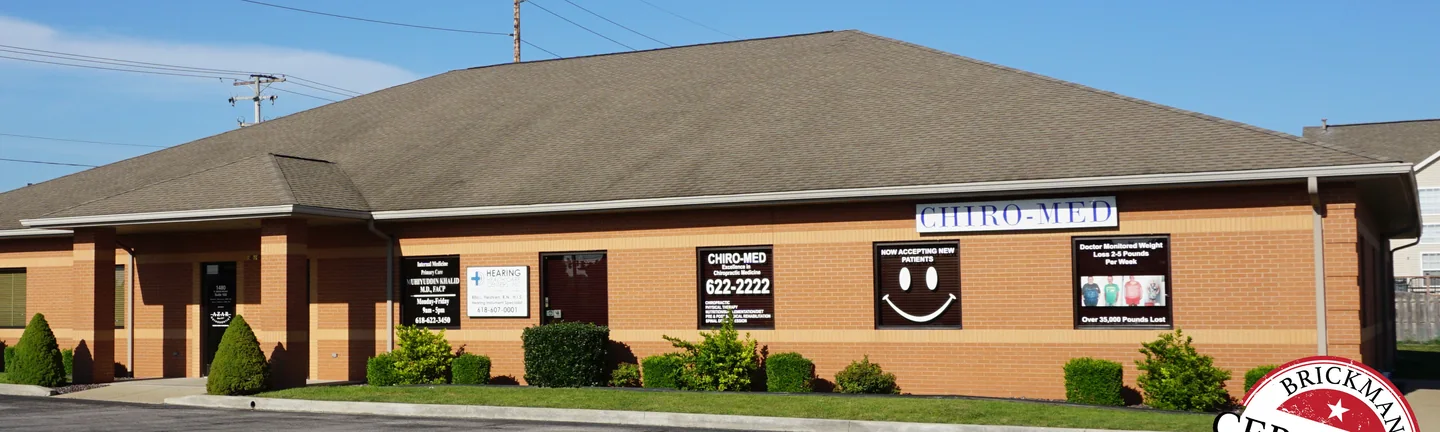 The O'Fallon office in 2019, a buff soldier band running level below the window line of its orange brick wall