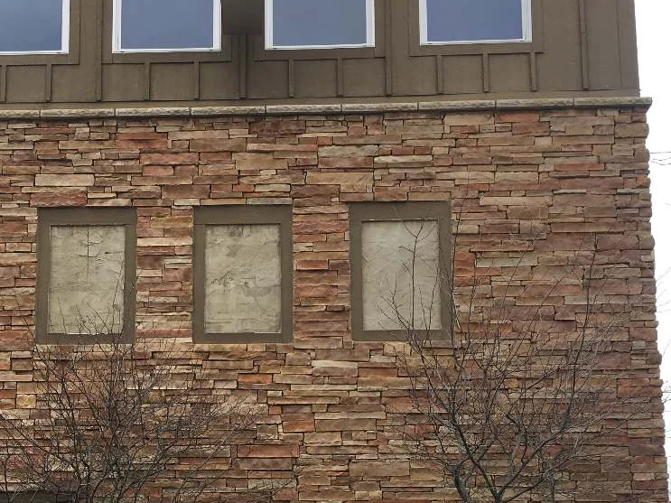 A closer look at the same three panels in 2021, the stacked stone courses even in tone across the face with no fading, blistering or flaking at the joints