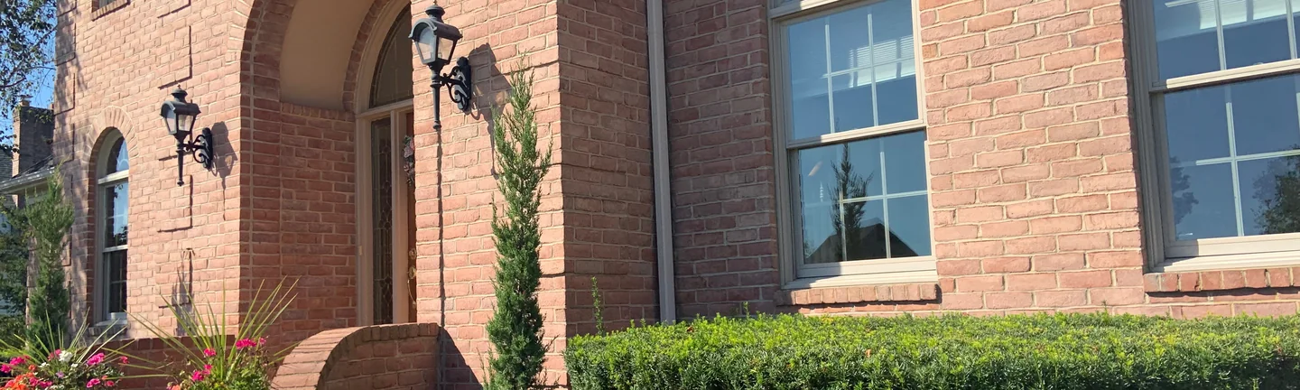 The arched brick entry of the Ohio house in 2019, its brick reading as one even warm red range
