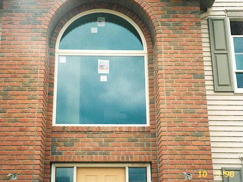 The two-story arched window bay in 1998, the brick around it reading mostly light red, with a camera date of 10 3 98 burned into the lower right of the frame
