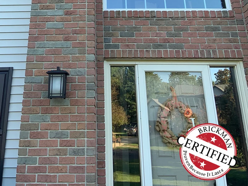 The front entrance in 2019 below the two-story arched window, the brick around it an even mix of red, tan and grey units