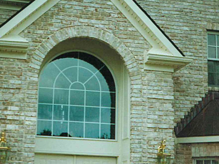 The arched front entrance in 1998, a brick arch turned over the tall transom and the surrounding wall running from cream to tan