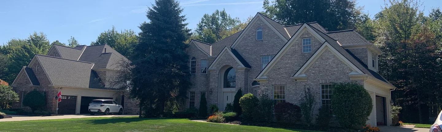 The Ohio house seen from across its front lawn in 2019, the cream brick reading as one even range across every gable