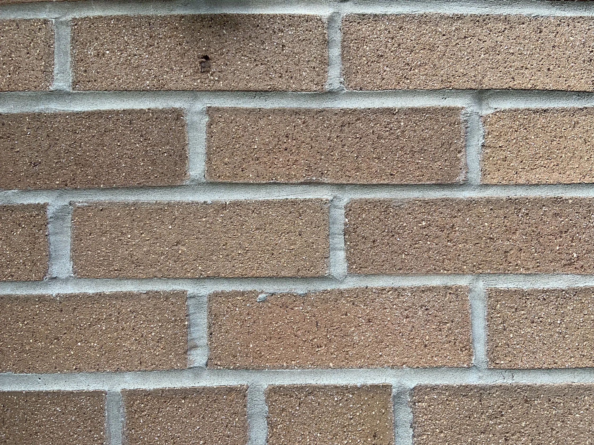 Close view of the brick and mortar in 2019, the sanded units an even tan brown with pale joints running between them