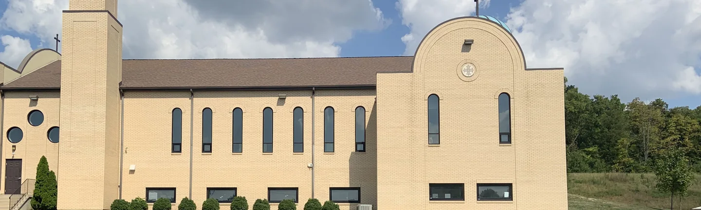 The long brick side of an Ohio church in 2019, its bell tower and arched window range reading as one even buff wall