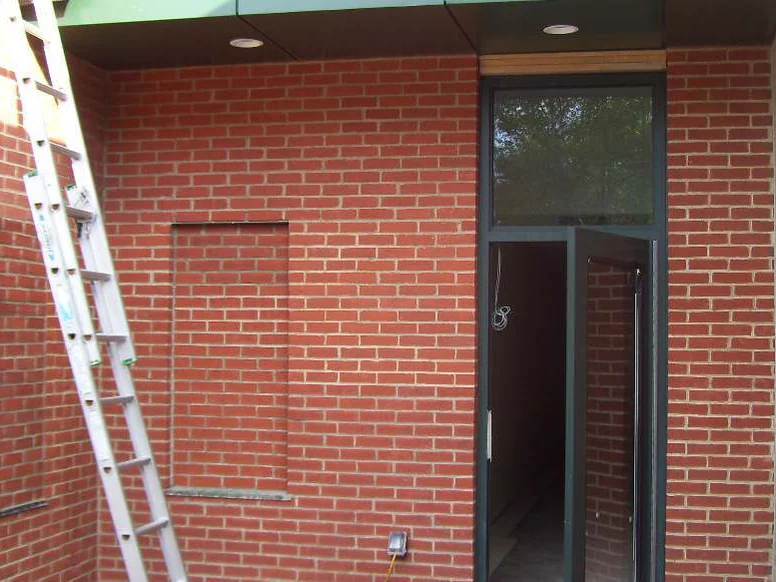 The same recessed vestibule in 2011 after staining, the brick around the door one even red with an extension ladder leaning against the wall