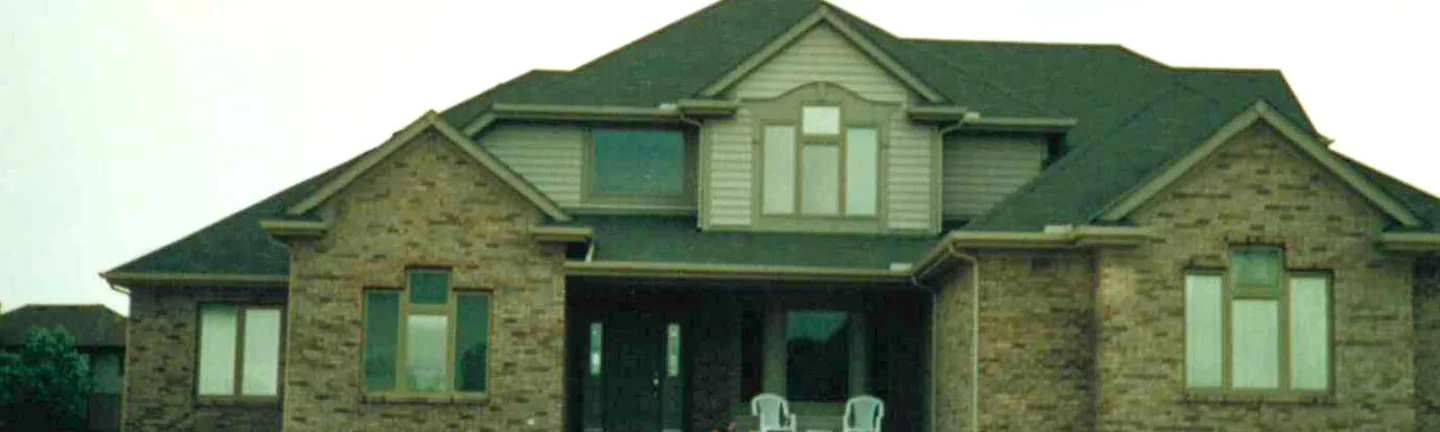 The front of the house in 1996 after the blend, light and dark brick running together across both gable wings and the covered porch between them
