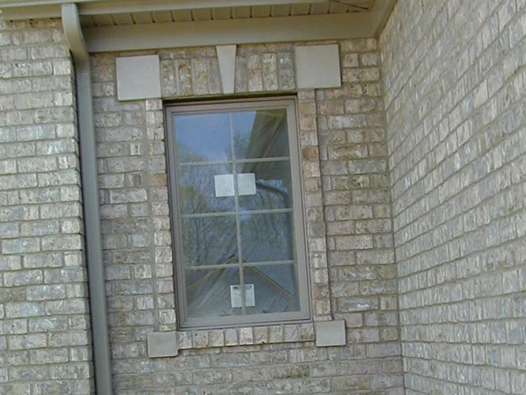 The same window in 2002 after staining, seen from further back under the soffit, the cut brick now sitting in the buff range that runs on around the outside corner