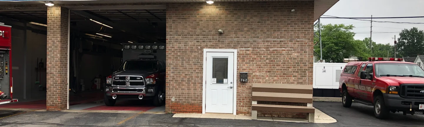 An Ohio fire station in 2019 with an apparatus bay open and an engine inside, its stained brick front wall alongside