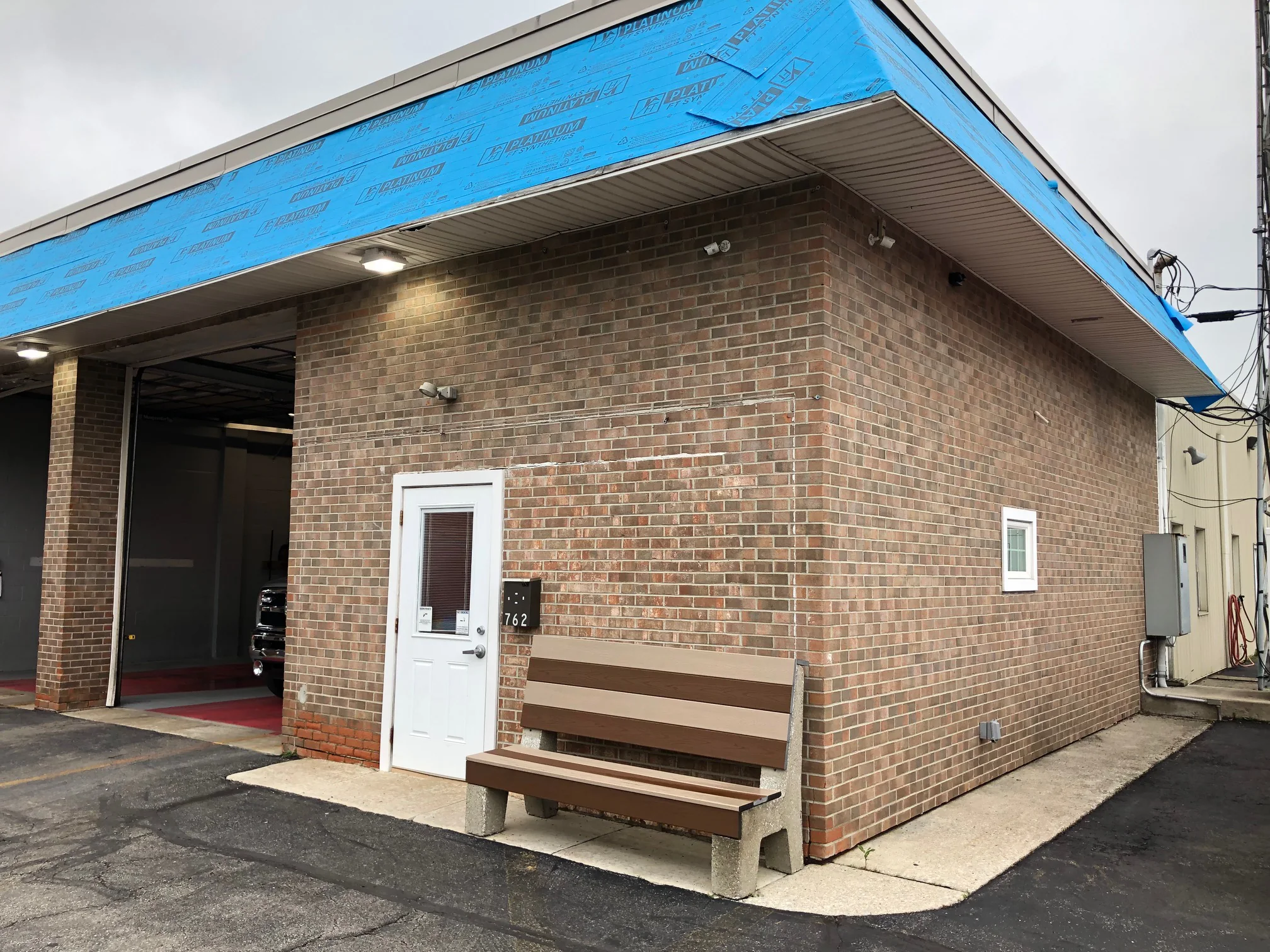 The corner of the fire station in 2019, the stained wall running back from the entry door to the far end of the building