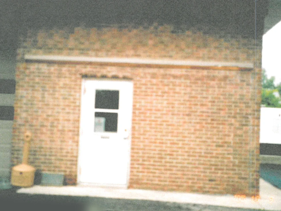 The same wall after staining in 2005, the repaired area now reading as part of the brick around it