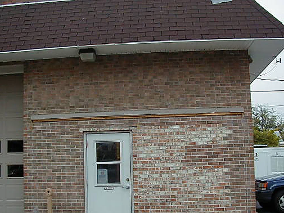 The wall beside the fire station door in 2005, a pale block of replacement brick standing out against the darker weathered brick around it