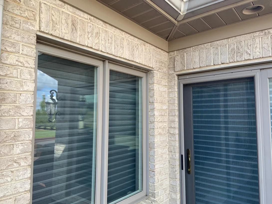 An outside corner at the windows in 2019, the brick a cream and buff range with pale mortar joints under the soffit