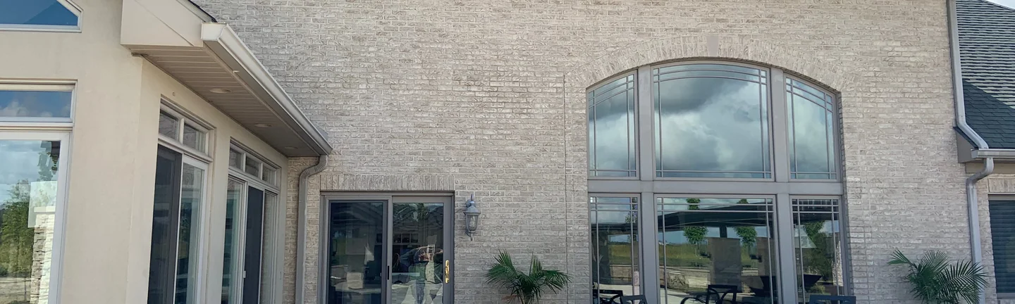 The rear of the Ohio house in 2019, its cream and tan brick running up to the eaves of a broad hipped roof